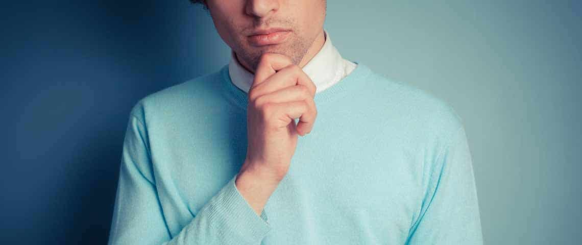 Young man is thinking touching his chin