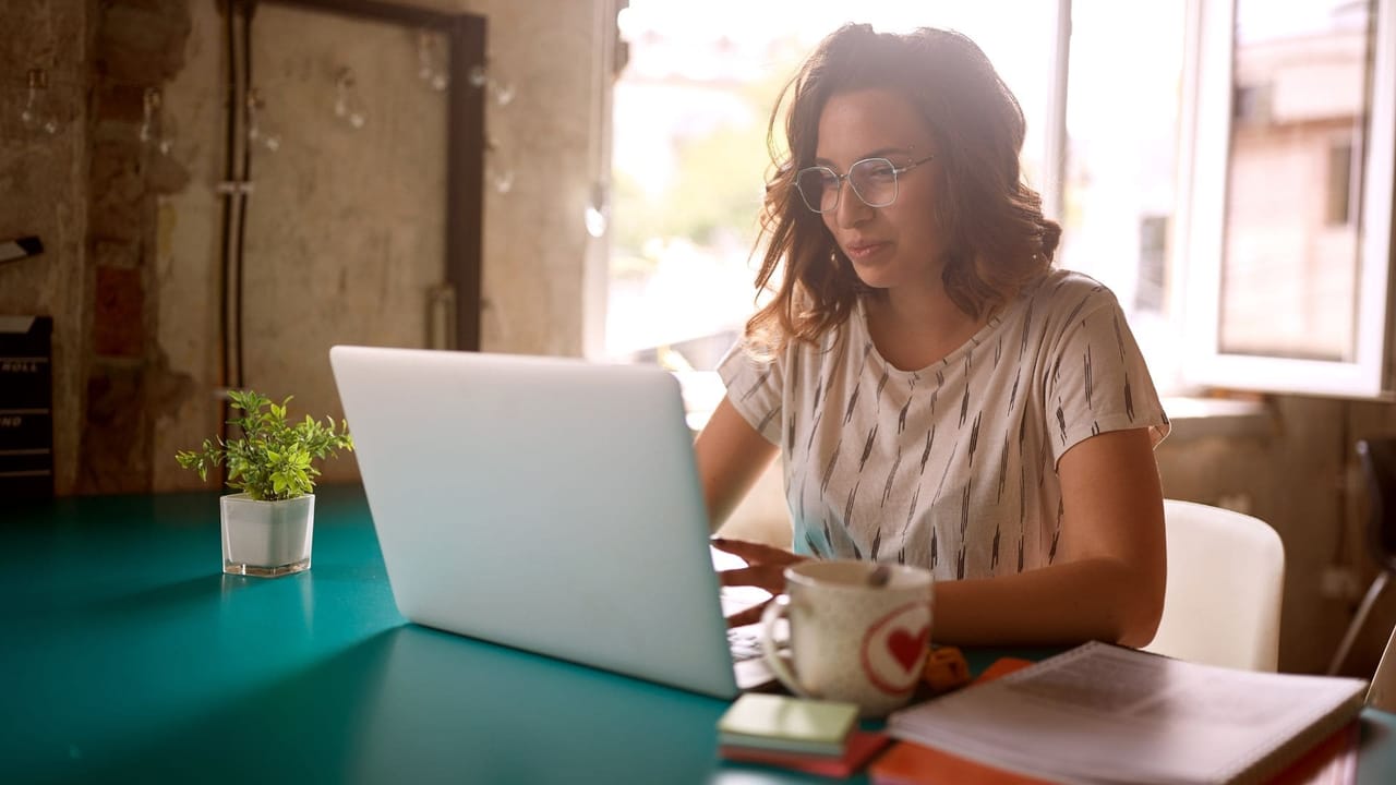 woman working on her laptop in a cafe and smiling