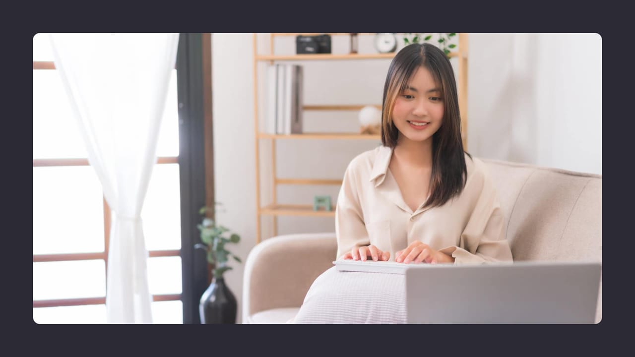 Woman working on laptop in bright home office