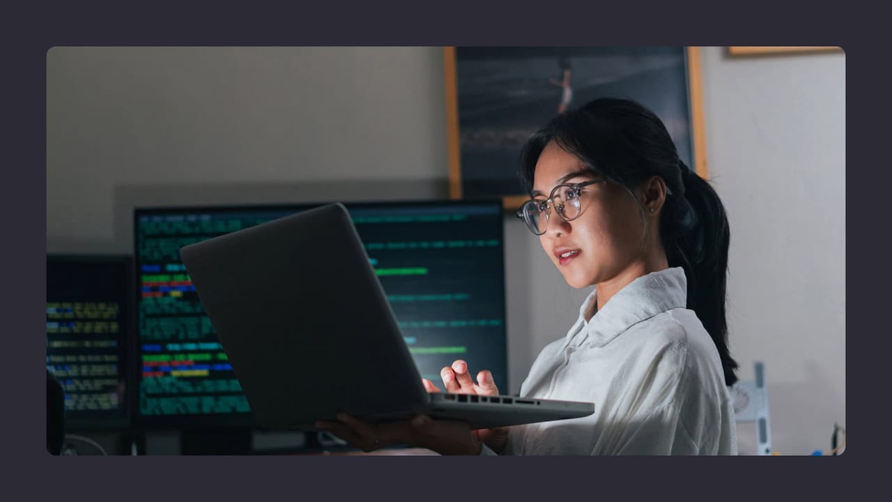 Woman coding on laptop in modern office