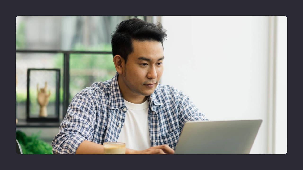 Man working intently on laptop in bright room