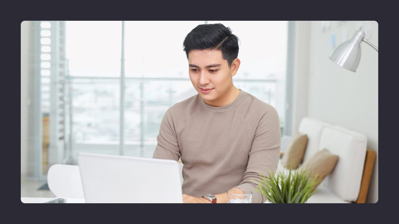 Man working on laptop in bright office setting