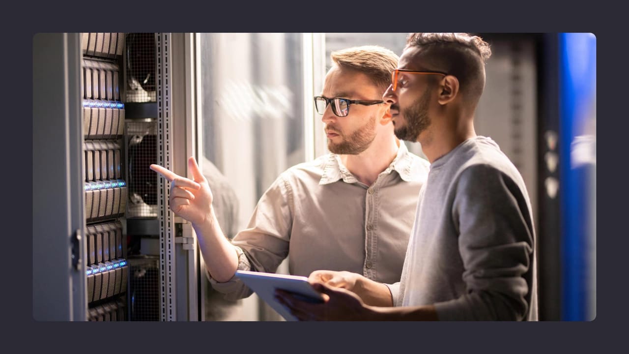 Two men examining server hardware in data centre