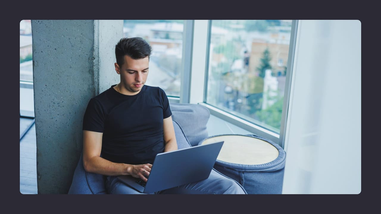 Man using laptop in modern office with city view