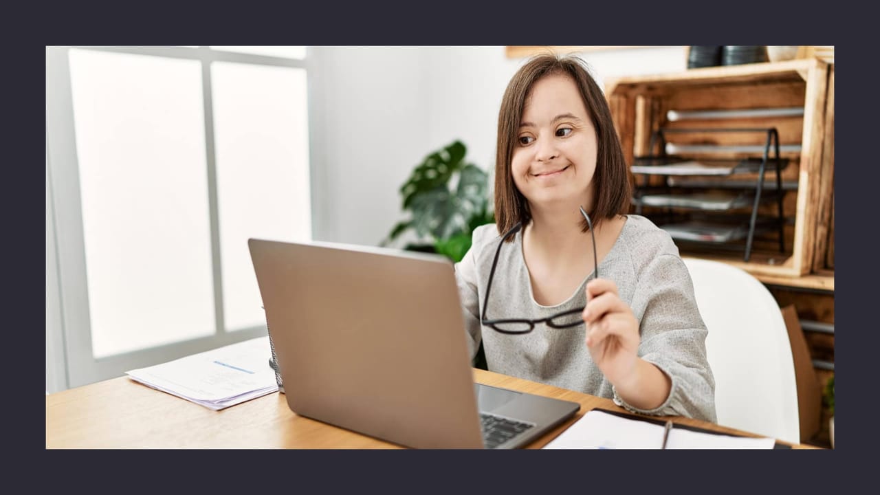 Woman with glasses working happily on laptop