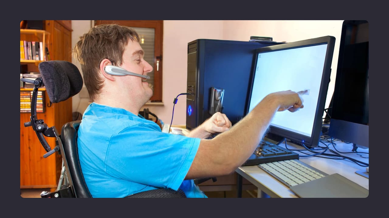 Disabled man using computer with assistive technology