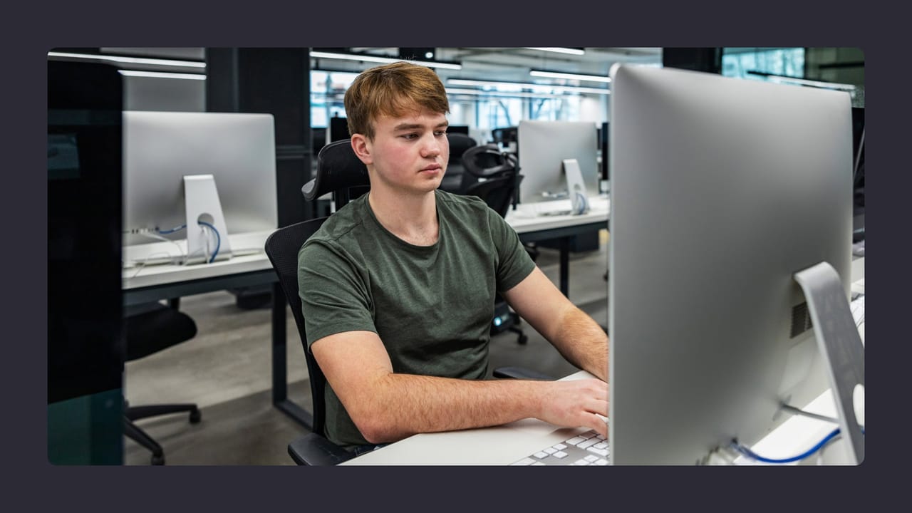 Young man working intently at computer in office