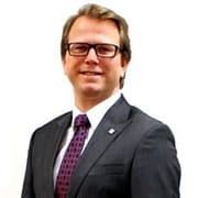 Businessman in suit smiling against white background.