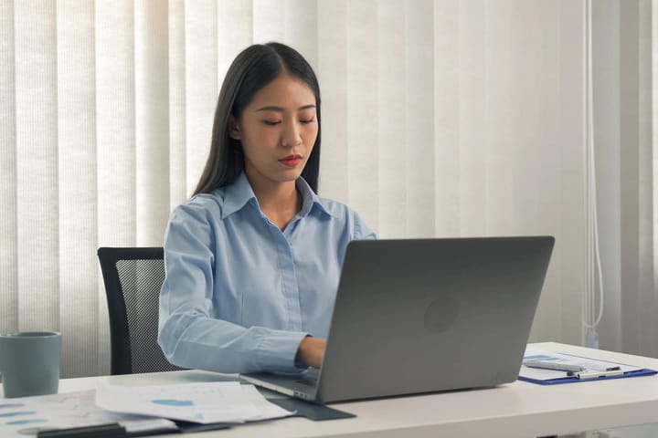 Woman working on laptop at office desk