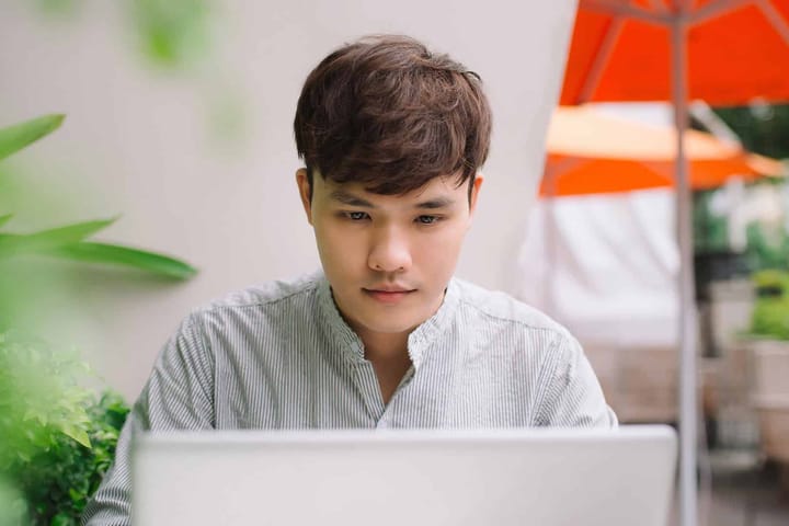 Person working on laptop outdoors.