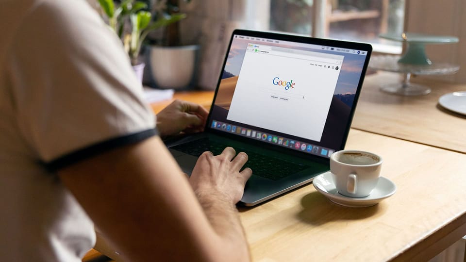 Person using laptop with Google on screen