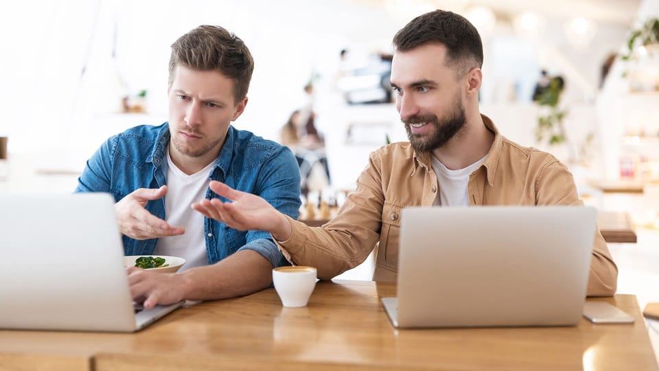 Two smart casual dressed men in a creative studio in discussion about website strategy.