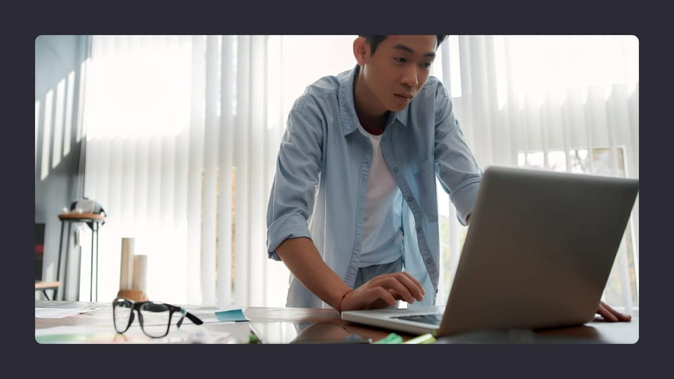 Young man concentrated on laptop in bright office