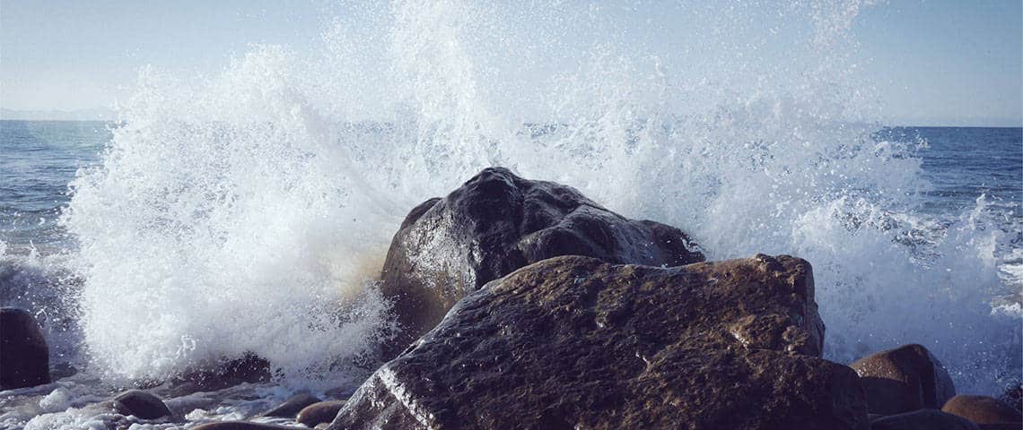 Sea waves crashing against big rocks in the ocean