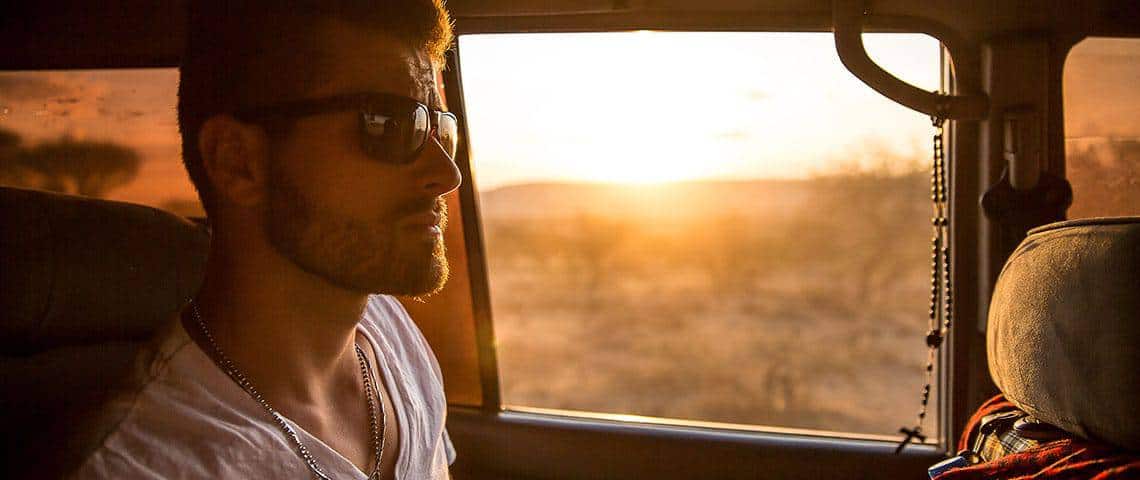 White male wearing dark sunglasses inside a car