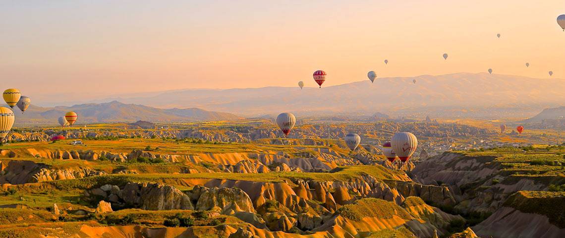 Hot air balloons soaring to the sky from an open valley