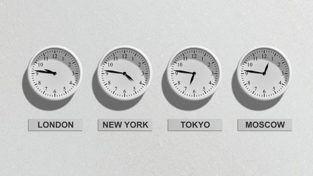 White clocks showing London, New York, Tokyo, and Moscow time mounted on a wall