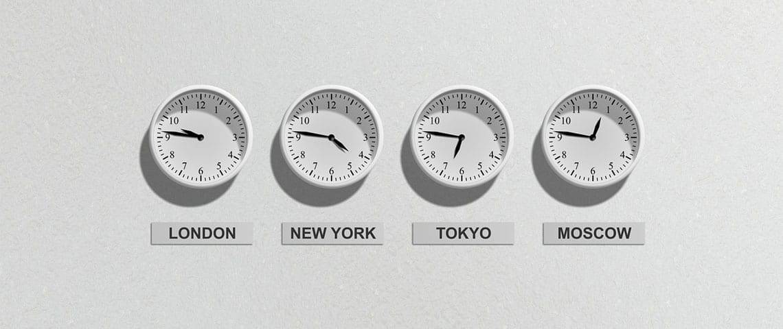 White clocks showing London, New York, Tokyo, and Moscow time mounted on a wall