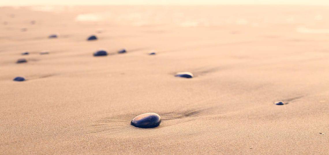 Smooth black stones strewn across dessert sands