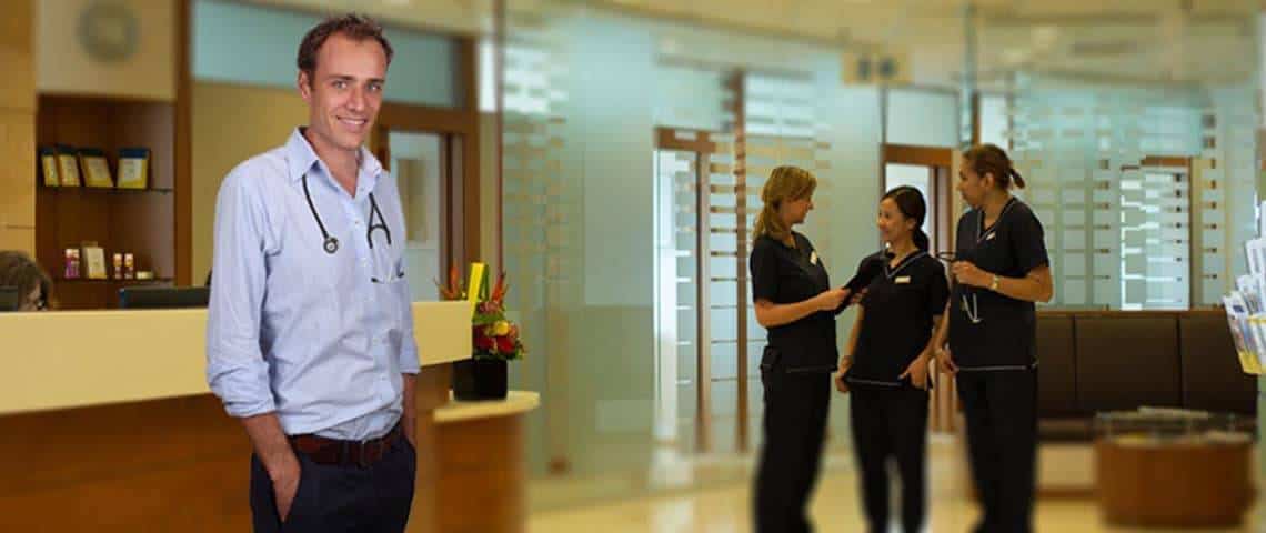Male doctor standing near a group of female nurses
