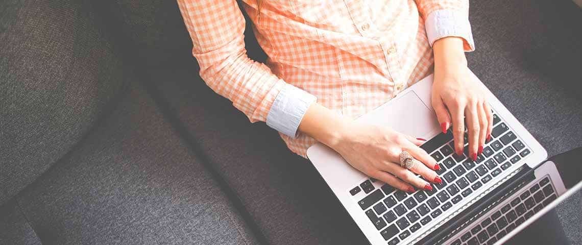 woman using laptop while sitting on the couch