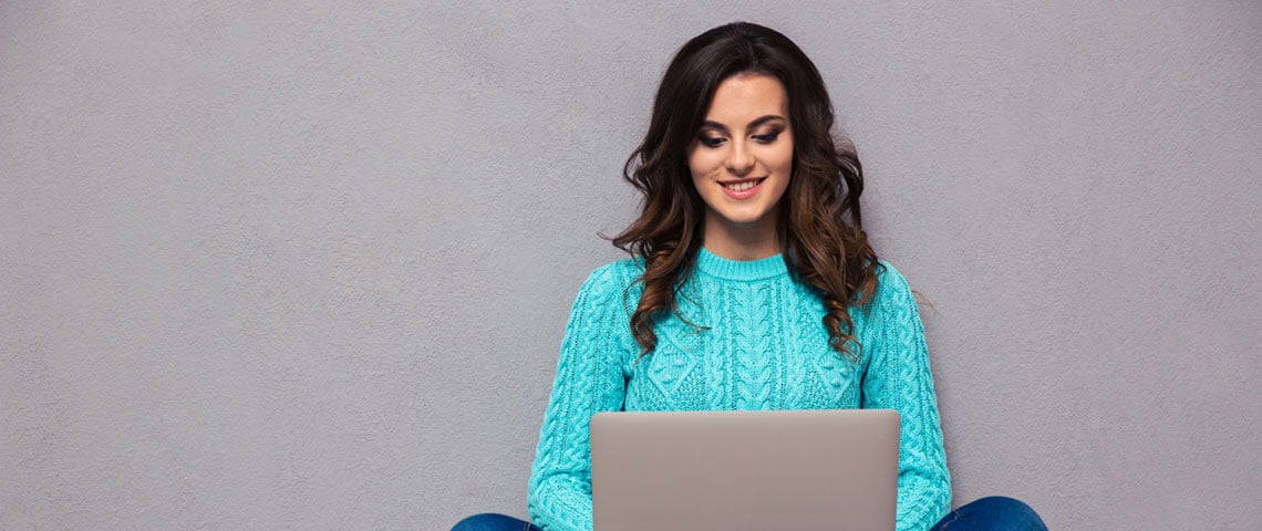 A woman typing at a computer wondering how often should you blog