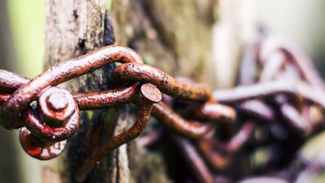 Rusty chain wrapped around a wooden post