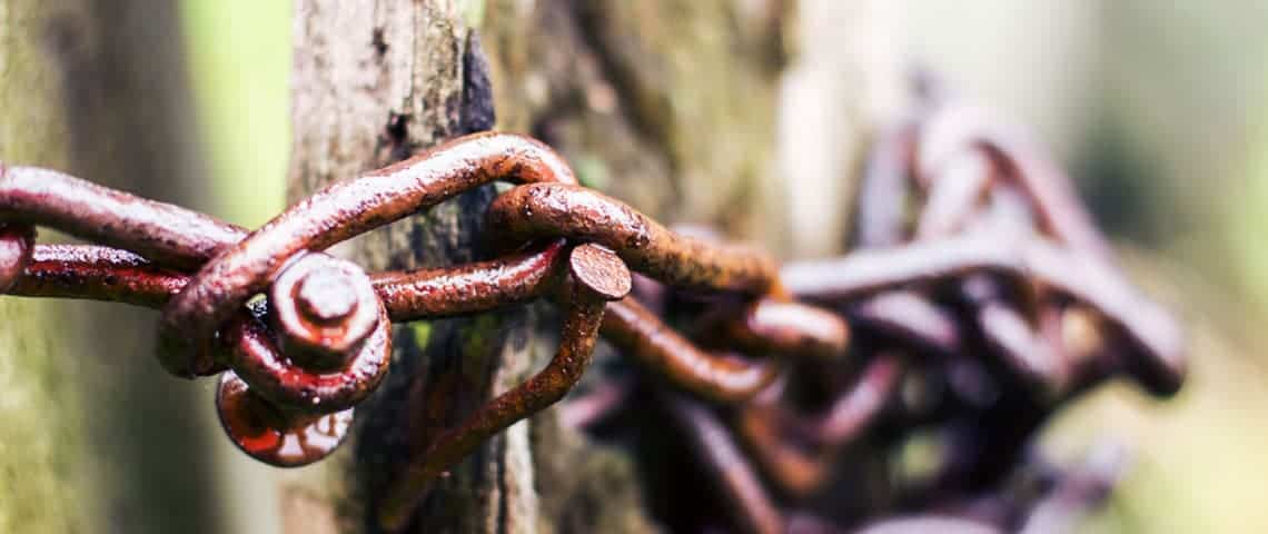 Rusty chain wrapped around a wooden post