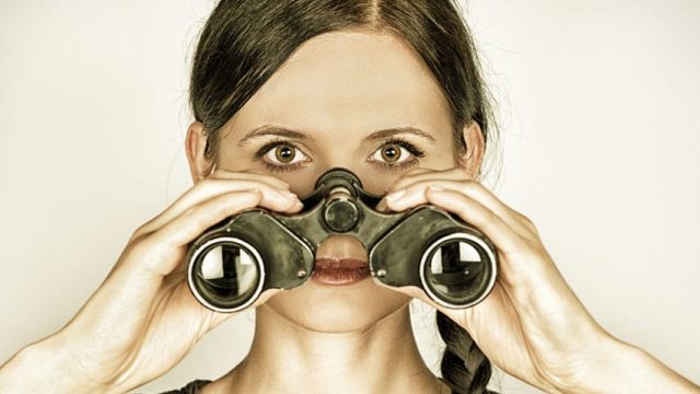 A woman with binoculars looking for negative seo