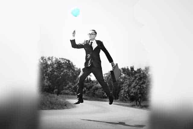 man floating with balloon