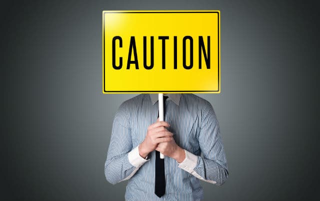 man holding caution sign board