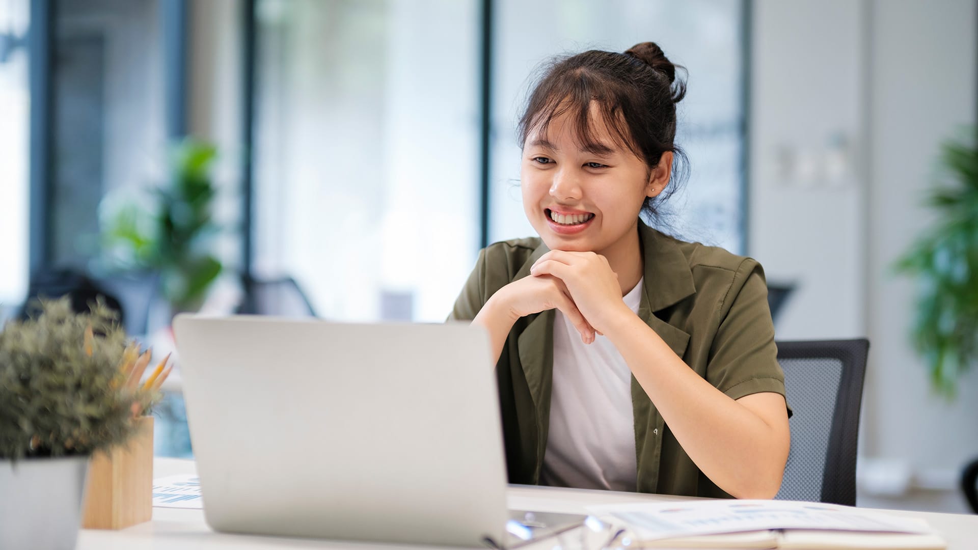 Asian woman working on a laptop researching the average budged needed for website development