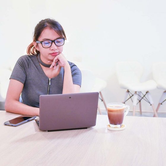 veena-sitting-desk-looking-laptop services wordpress maintenance veena square