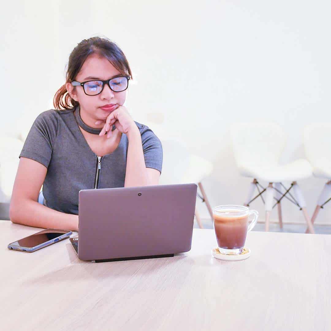 veena-sitting-desk-looking-laptop services wordpress maintenance veena square
