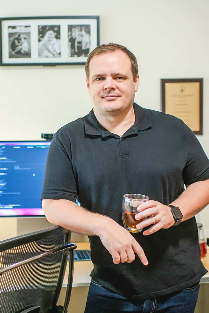 shaan nicol standing leaning desk behind