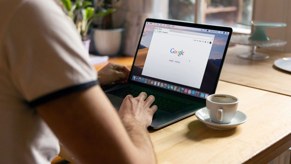 Person using laptop with Google on screen