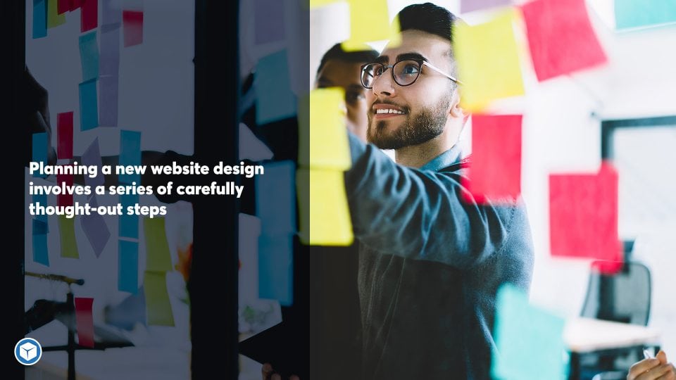 Man using sticky notes to plan out his web design project on a glass panel.