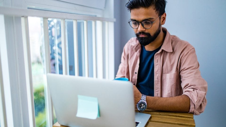 Freelancer sitting at a desk working on a website for a relative.