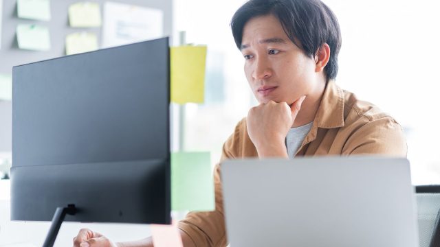 man working on his computer in the office, thinking deeply