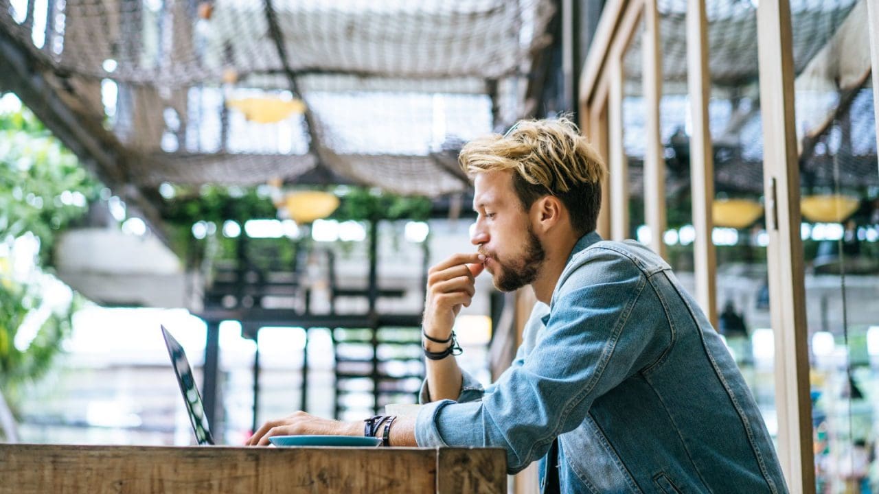 man working on his laptop in a cafe