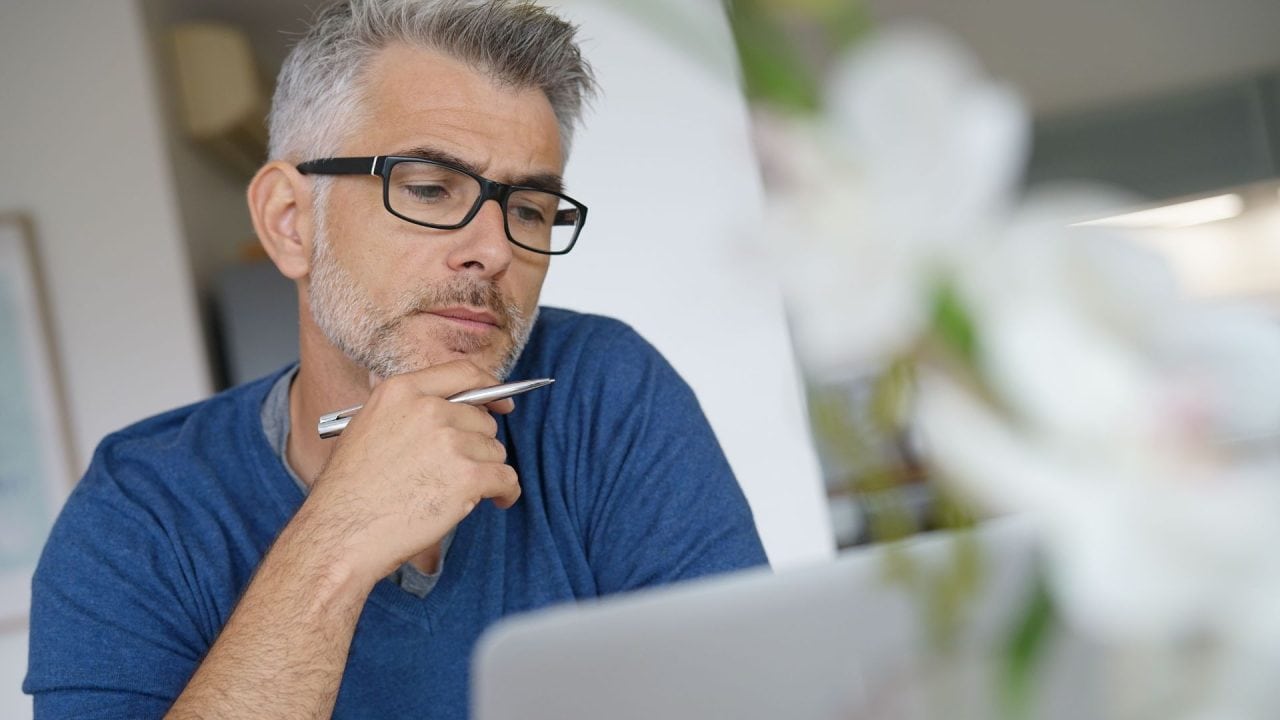 man working on his laptop and thinking