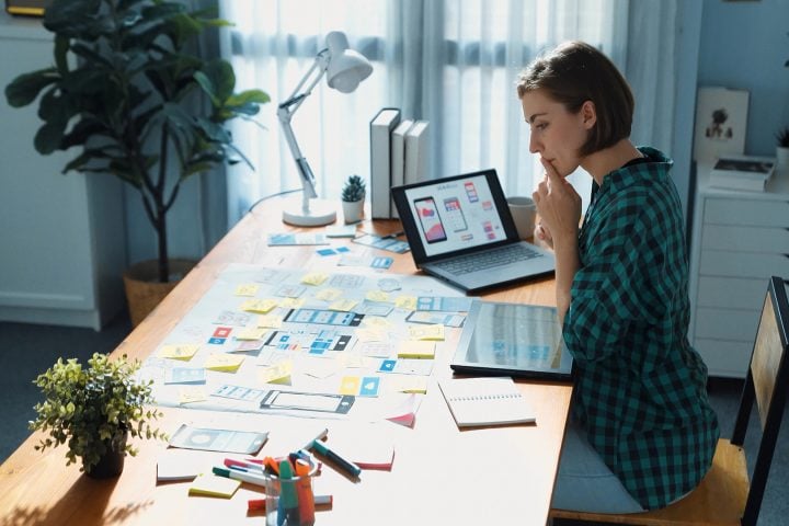 Woman designing app interfaces in office workspace