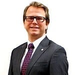 Businessman in suit smiling against white background.