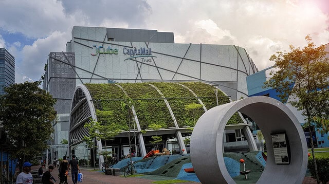 JCube shopping centre exterior with greenery and sculpture.