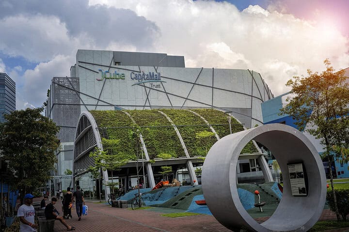 JCube shopping centre exterior with greenery and sculpture.