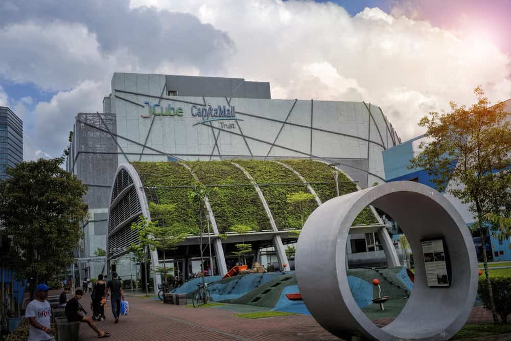 JCube shopping centre exterior with greenery and sculpture.