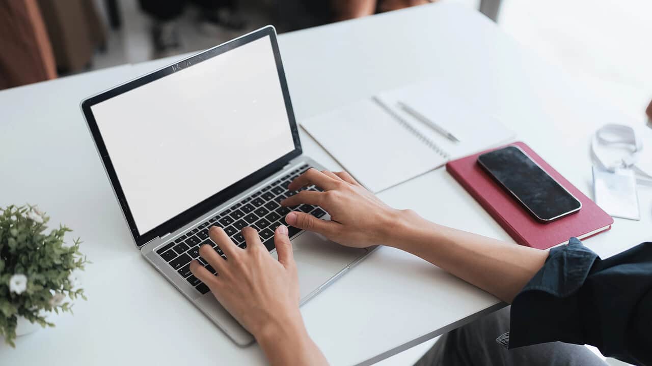 Person typing on laptop at white desk